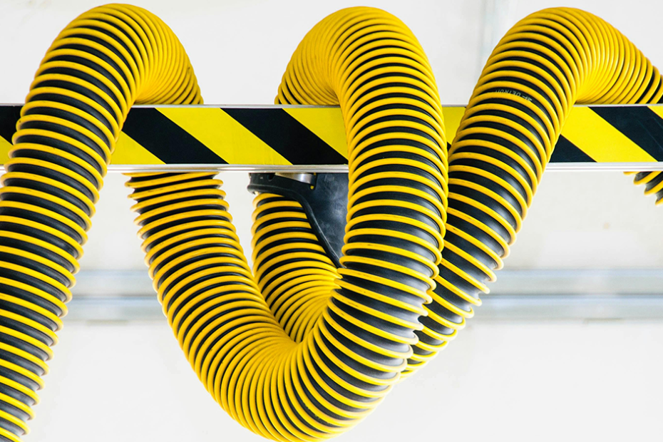 photo of bright yellow and black hydraulic hose wrapped around a caution bar